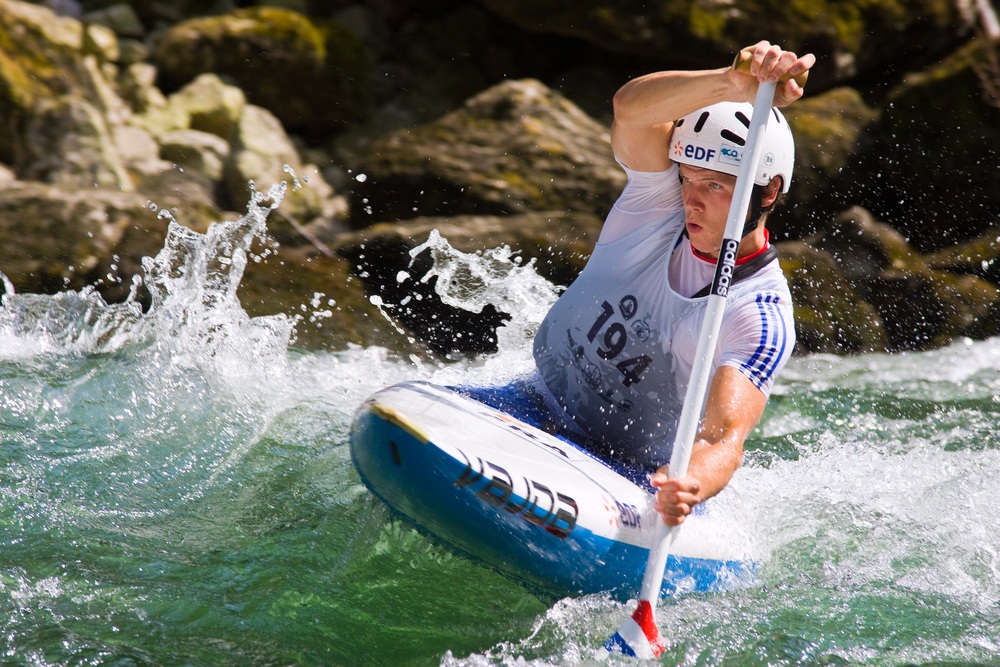 In this canoe slalom, a competitor fights rough water to execute quick turns along a natural river course. (Evronphoto/ Shutterstock)