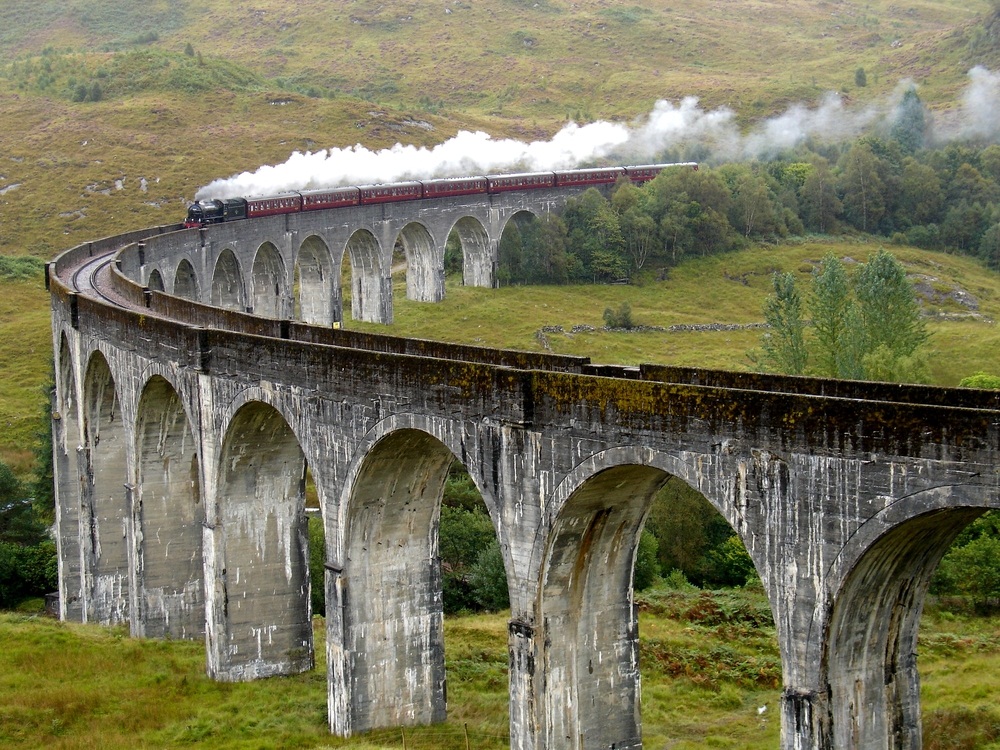 Here, a steam train called the Jacobite puffs through Scotland. The steam engine is on a locomotive at the front of the train, and the locomotive pulls the rest of the train down the tracks. The Jacobite appeared as the Hogwarts Express in the Harry Potter movies. (Serjio74/ Shutterstock)
