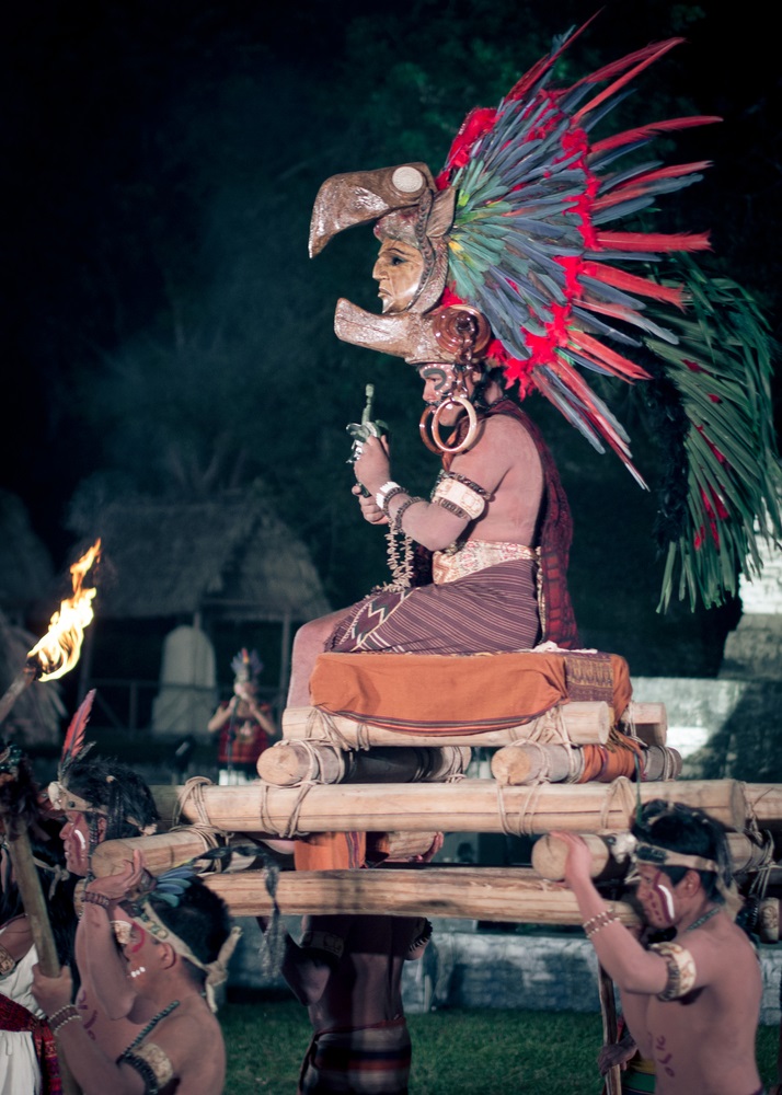 Reenacting a royal procession, a man portrays one of the kings of Tikal being carried on a ceremonial litter and wearing a feathered headdress. (davesimon/ Shutterstock) 