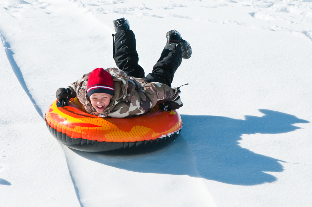 An object moves faster when there is less friction to slow it down. The slick plastic of the inner tube and the smooth packed-down snow are a low-friction combination. (Shutterstock / Tammy Kay Photo)